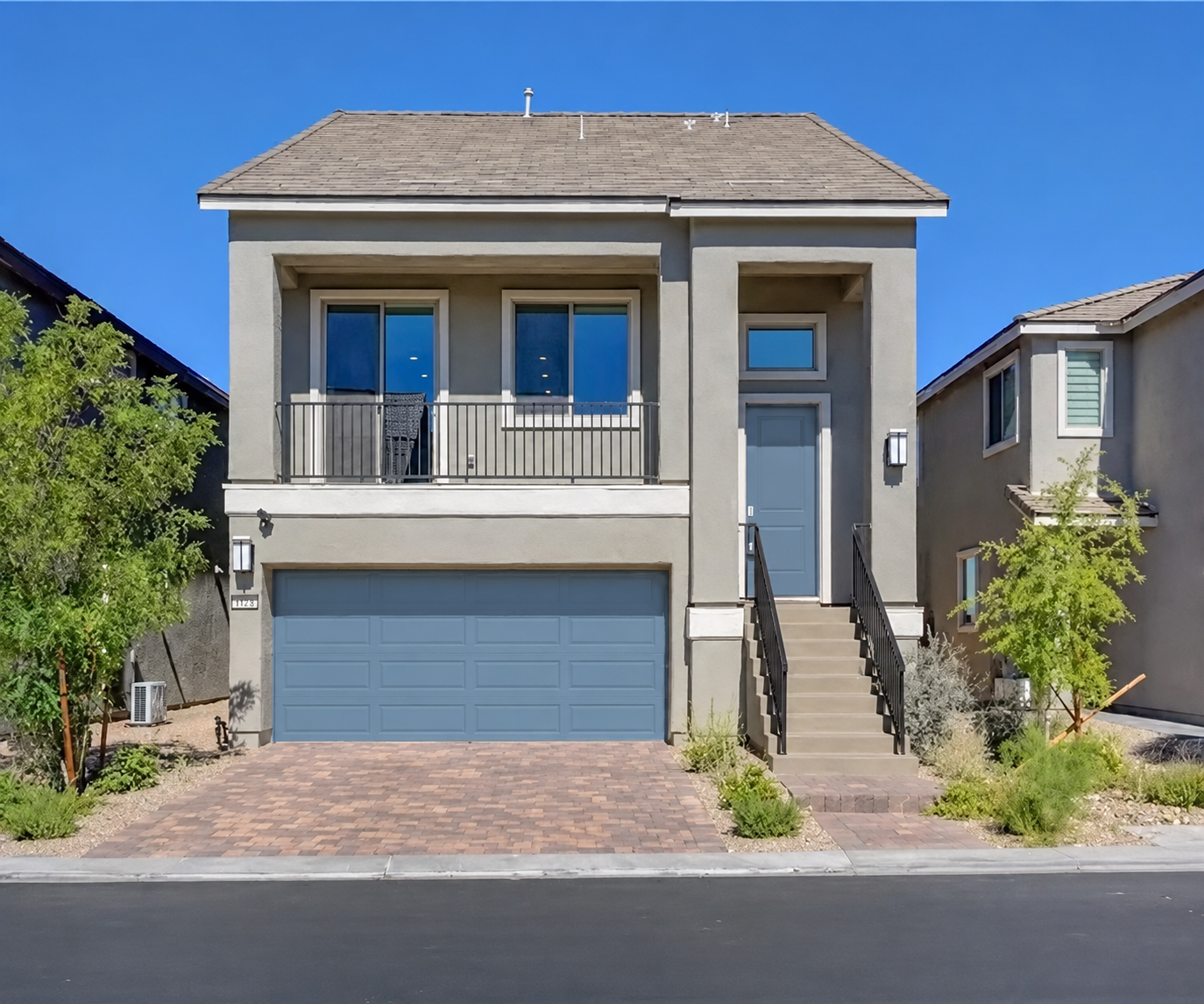 Two-story stucco home with blue garage and entry doors